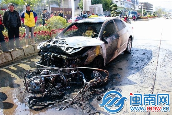 火被撲滅后，小車前躺著一輛被燒得只剩鋼架的助力車