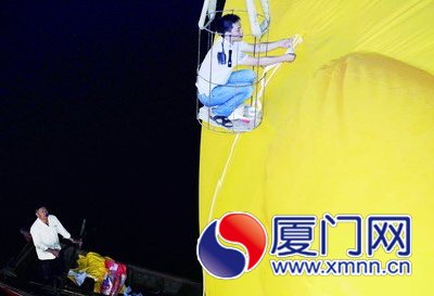 工人給大黃鴨系上繩子，準備起吊