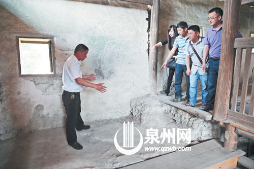 許進丁向游客們比劃著土樓墻體的厚度，當年建造土樓