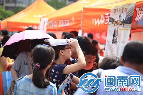 海都咨詢會現場，一名家長頂著烈日看學校信息