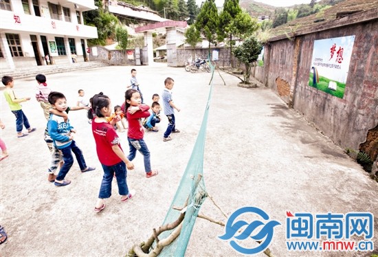 幾名小學生在操場上玩，學校的圍墻歪了一邊，用簡易
